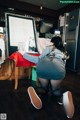 A woman kneeling on the floor in front of a menu.