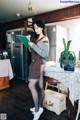 A woman standing in a kitchen holding a clipboard.