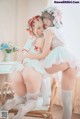 A couple of women sitting on top of a wooden chair.