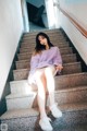 A woman sitting on the steps of a building.