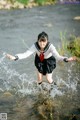 A woman in a school uniform is standing in the water.