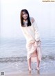 A woman standing in the water at the beach.