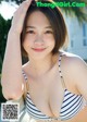 A woman in a blue and white striped bikini posing for a picture.