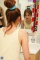 A woman looking at herself in the mirror. 