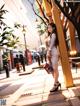 A woman in a white dress is walking down the street.