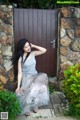 A woman sitting in front of a wooden door.